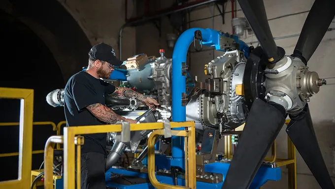 Collins Aerospace technician testing a hybrid-electric flight demonstrator engine